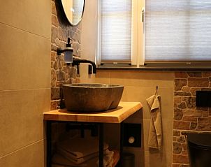 Trap met houten leuning in Huisje in Wijnaldum, vakantiehuis op het Friese platteland.