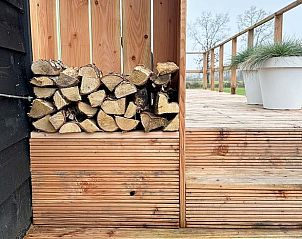 Houtopslag en terras bij Vakantiehuis in Eastermar, ideaal voor buitenavonden.