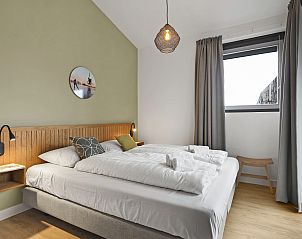 Stijlvolle zithoek in 4-persoons woning 4L, Witmarsum, met wijn en glazen, perfect voor ontspanning op het Friese platteland.