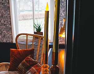 Sfeervolle hoek met kaarsen in Vakantiehuisje in Garyp, perfect voor een ontspannen avond.