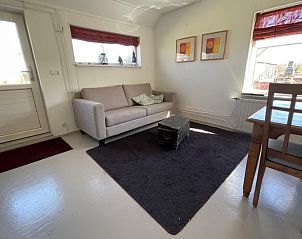Gezellige woonkamer in Huisje in De Westereen, vakantiehuis op het Friese platteland, Friesland. Comfortabele zithoek en licht interieur.