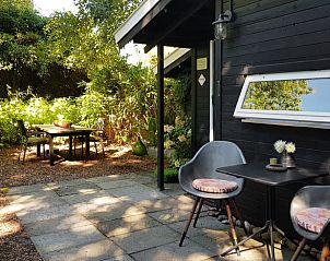 Schaduwrijke tuin bij Vakantiehuis in Kootstertille, een oase van rust op het Friese platteland.