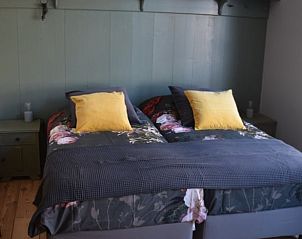 Gezellige slaapkamer in Vakantiehuisje in Munnekeburen, Friesland met comfortabele bedden en kleurrijke kussens.