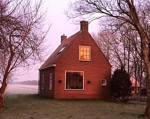 Vakantiehuis in Munnekeburen bij zonsondergang, Friesland.