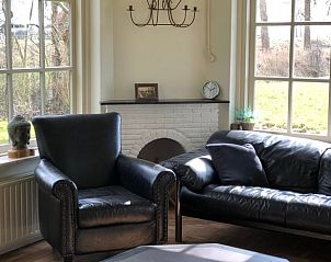 Gezellige woonkamer in Vakantiehuis in Munnekeburen, met uitzicht op het Friese platteland.