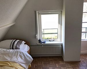 Knusse slaapkamer in Vakantiehuis in Munnekeburen met uitzicht op het Friese landschap.