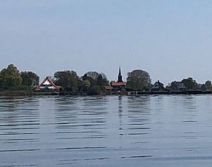 Uitzicht op het dorp vanaf het meer nabij Vakantiehuis in Munnekeburen, Friesland.