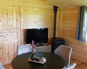 Gezellige binnenruimte van Vakantiehuisje in Munnekeburen met houtinterieur en tv.