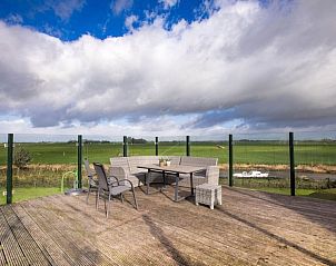 Buitenterras met zitgelegenheid en uitzicht op het Friese platteland bij Recreatieboerderij Slachtehiem, Lollum, Friesland.