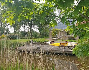 Idyllisch terras met kano bij Vakantiehuis in Lollum, omgeven door natuur.