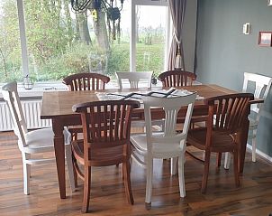 Eetkamer met uitzicht op de tuin in Vakantiehuis in Lollum, Friesland.