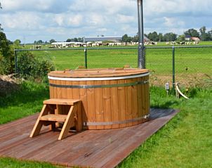 Houten hottub met uitzicht op weilanden bij Vakantiehuis in Oldetrijne, Friesland.