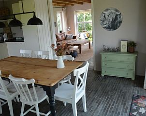 Eetkamer met uitzicht op natuur in Vakantiehuis in Oldetrijne, Friesland.