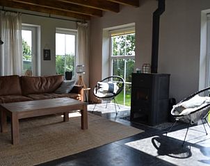 Lichte woonkamer met houtkachel in Vakantiehuis in Oldetrijne, Friesland.