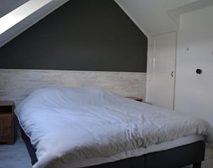 Hedendaagse slaapkamer met groot bed in Vakantiehuis in Oldetrijne, Friesland.