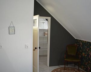 Stijlvolle slaapkamer met vintage stoel in Vakantiehuis in Oldetrijne, Friesland.