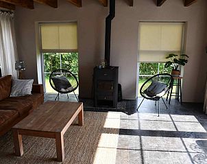 Zithoek met kachel in de woonkamer van FR125 vakantiehuis, Oldetrijne, Friesland.