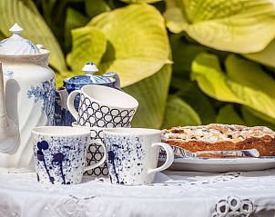 Rustieke tuinsetting in Vakantiehuis in Drogeham, Friesland, met uitnodigende zitjes.