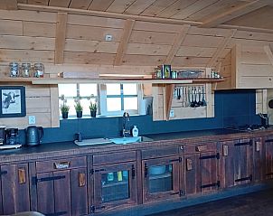Volledig uitgeruste keuken in Vakantiehuisje in Drogeham, Friesland, met moderne apparatuur en houten afwerking.
