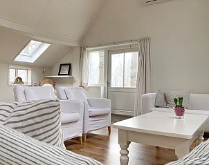 Ruime woonkamer met veel lichtinval in Huisje in Longa, ideaal voor ontspanning.