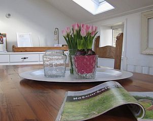Stijlvolle eethoek met bloemen in Huisje in Longa, Friesland, voor gezellige maaltijden.