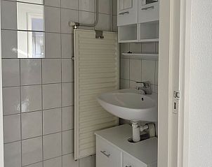 Badkamer met wastafel en spiegel in Huisje in Longa, ideaal voor comfort.