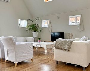 Ruime woonkamer in Vakantiehuisje in Longa met gezellige inrichting en houten vloer.