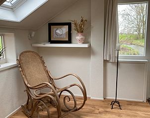 Knusse hoek met schommelstoel in Vakantiehuisje in Longa, perfect voor ontspanning.