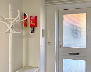 Ingang van Vakantiehuisje in Longa met moderne deur en kapstok voor gemak.