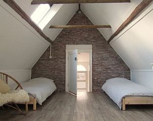 Gezellige zolderkamer in Vakantiehuisje in Longa met twee bedden en rustieke details.