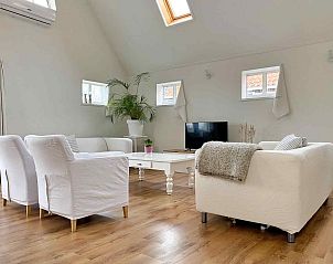 Lichte eetkamer van vakantiehuis FR424 in Longa, Friesland met houten meubels en dakramen.