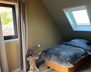 Knusse slaapkamer in vakantiehuis in Spanga met houten elementen en comfortabel bed.