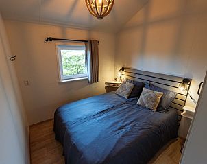 Slaapkamer in Huisje in Nij Beets, vakantiehuis in Nij Beets, met comfortabel bed en warme ambiance.