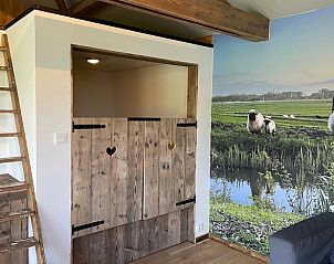 Rustieke binnenruimte van Huisje in Gonga met houten accenten en uitzicht op de natuur.