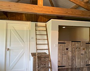 Houten trap en deur in de binnenruimte van Huisje in Gonga, Friesland.