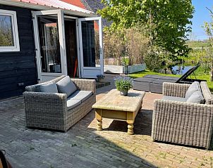 Zonnig terras bij Huisje in Gonga met comfortabele tuinmeubelen en uitzicht op de natuur.