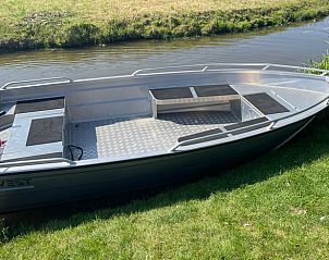Aluminium boot aangemeerd bij Huisje in Gonga, ideaal voor verkenning van Friesland.