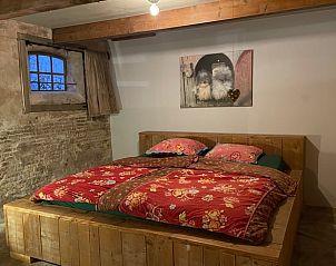 Knusse slaapkamer met houten bed in Vakantiehuis in Gonga, ideaal voor een rustgevende nacht op het Friese platteland.