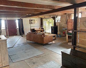 Ruime binnenruimte met zithoek in Vakantiehuis in Gonga, Friesland, biedt een warme sfeer voor gasten.