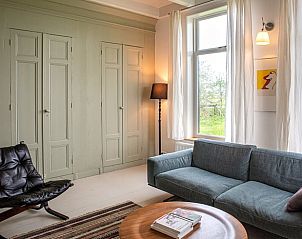 Stijlvolle zithoek in Vakantiehuisje in Tzummarum, met uitzicht op het Friese platteland.