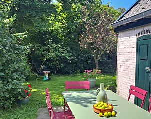 Tuin met eettafel en groene omgeving bij Vakantiehuisje in Tzummarum, Friesland.