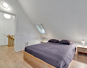 Ruime slaapkamer met houten meubels in Huske 2 vakantiehuis, Tzummarum, Friesland.