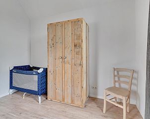 Kinderbedje en houten kast in Huske 2 vakantiehuis, Tzummarum, Friesland.