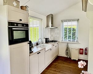 Achterzijde van vakantiehuis FR463 in Tzummarum, met picknicktafel en groene omgeving, Friesland.