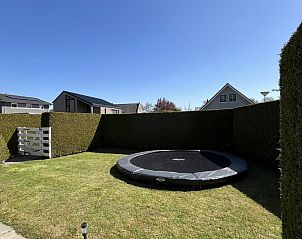 Groene tuin met trampoline bij vakantiehuis FR463 in Tzummarum, perfect voor spelende kinderen, Friesland.