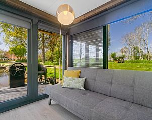 Lichte woonkamer met prachtig uitzicht in Vakantiehuisje in Weidum, ideaal voor ontspanning in Friesland.