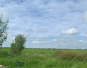 Uitzicht op het uitgestrekte Friese platteland vanuit Vakantiehuis in Britswert.