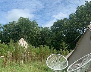 Zithoek buiten een safaritent bij Vakantiehuis in Britswert, omgeven door natuur.