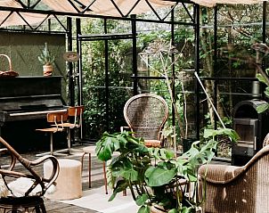 Serre met planten en piano bij Huisje in Britswert, vakantiewoning in Friesland.