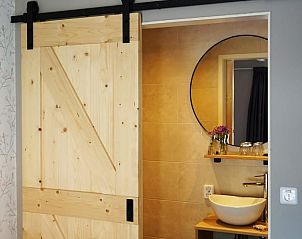 Moderne badkamer met houten schuifdeur in Vakantiehuis in Wjelsryp, Friesland.